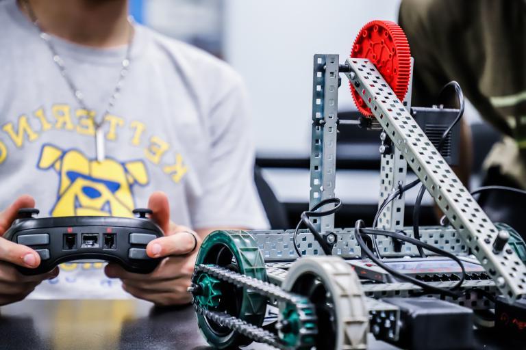 student controls a robot at kettering university